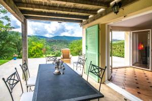 eine Terrasse mit einem Tisch und Stühlen auf einer Veranda in der Unterkunft Esprit du Sud Fionna in Roquebrune-sur-Argens