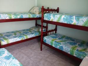 Dos literas en una habitación con suelo en Apartamento Aconchego da vovó, en Peruíbe