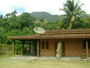 una pequeña casa con un satélite en el techo en Casa Curral, en Ilhabela