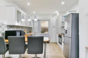 a kitchen with a table and chairs and a refrigerator at Beckenham Place - Free Parking - Self Check-in in Bromley