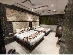 a bedroom with two beds in a room at Hotel Privilege View in Ahmedabad