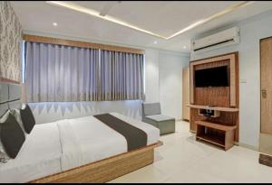 a bedroom with a bed and a flat screen tv at Hotel Privilege View in Ahmedabad