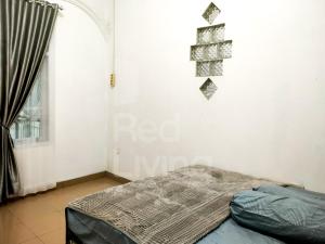 - une chambre avec un lit dans une pièce dotée d'une fenêtre dans l'établissement Guest House Syariah Bunga Intan RedPartner, à Metro