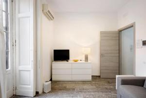 a living room with a tv on a white dresser at Appartamento Al Corso in Salerno