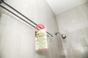 a sign in a shower in a bathroom at Istanaku Guesthouse 2 in Manado