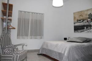 a bedroom with a bed and a chair and a window at Les Portes in Xàtiva