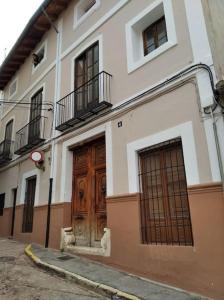 a building with a large wooden door on a street at Les Portes in Xàtiva