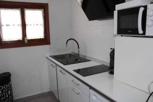 a white kitchen with a sink and a refrigerator at Les Portes in Xàtiva