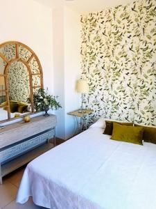 1 dormitorio con cama blanca y espejo en Villa Martiniano, en Campano
