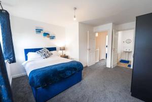 ein Schlafzimmer mit einem blauen Bett in einem Zimmer in der Unterkunft Immaculate 4-Bed House in Kings Norton in Birmingham