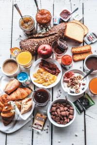 a table topped with plates of breakfast foods and bread at B&B HOTEL Saint-Pierre-en-Faucigny Bonneville in Saint Pierre en Faucigny