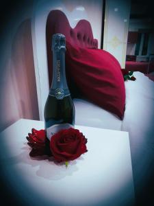 eine Flasche Champagner und eine Rose auf dem Bett in der Unterkunft IL NIDO Suite in Fiuggi