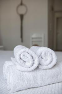 2 asciugamani laminati posti sopra un letto di Villa Fiamegou Andros a Mpatsi (Batsi)