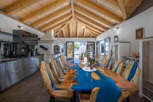 cocina y comedor con mesa azul y sillas en Villa Dalmatinac i Dalmatinka with heated pool, en Murvica