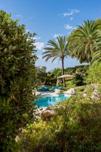 a swimming pool with palm trees and blue chairs at Azzurra Home-Charming Property- For 6 guests in Benissa