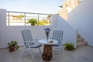 a table and two chairs on a balcony at Meltemi Beach Apartments 2 in Milatos