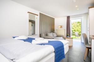 ein Hotelzimmer mit 2 Betten und einem Wohnzimmer in der Unterkunft Hotel Zur Seemöwe in Kirchdorf