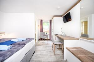 a hotel room with a bed and a desk at Hotel Zur Seemöwe in Kirchdorf