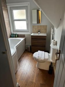 a bathroom with a tub and a toilet and a sink at High Wycombe Centre- 2 bed flat in Buckinghamshire