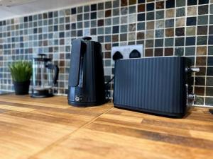 two black appliances sitting on top of a counter at High Wycombe Centre- 2 bed flat in Buckinghamshire