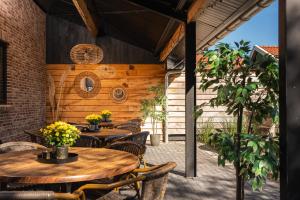 un patio esterno con tavoli e sedie in legno di de Familieboerderij a Losser