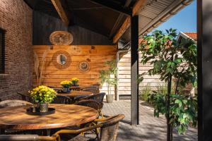 een patio met houten tafels en stoelen bij de Familieboerderij in Losser