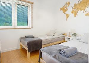 a bedroom with two beds and a world map on the wall at Apartament na Wzgórzu in Kudowa-Zdrój