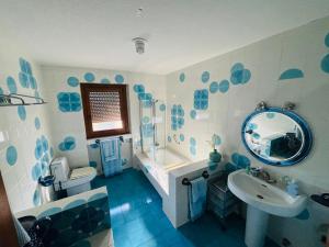 niebiesko-biała łazienka z umywalką i lustrem w obiekcie Casa Rural Finca el Cerrillo w mieście Navalafuente