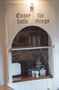 a kitchen cabinet with a shelf with a fireplace at The Wee House in Pennan