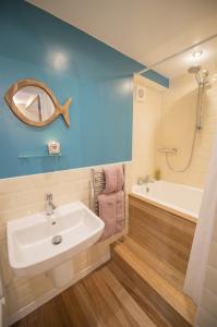 The Wee House في Pennan: حمام مع حوض وحوض استحمام