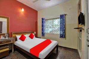 1 dormitorio con cama, escritorio y ventana en OYO Hotel Sahara Residency, en Narasimharaja Puram
