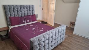 a bedroom with a large bed with a purple blanket at Family home three bed house near the beach in Herne Bay