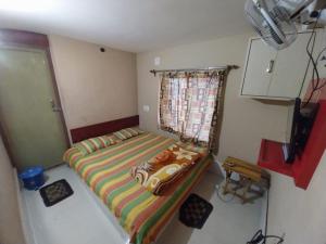 a small bedroom with a bed in a room at Home stay world in Bolpur