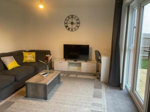 a living room with a couch and a flat screen tv at Impeccable 3-Bed House in Northampton in Northampton