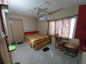 a bedroom with a bed and a ceiling fan at Home stay world in Bolpur