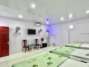 - une chambre avec 2 lits, une table et des chaises dans l'établissement Thuỷ Quỳnh hotel, à Xóm Bên Ðông