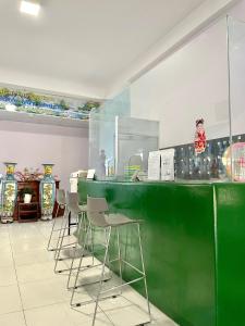 - un bar vert avec des chaises dans une pièce avec des vases dans l'établissement Thuỷ Quỳnh hotel, à Xóm Bên Ðông