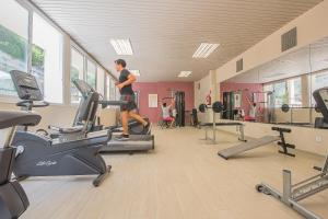 a woman running on a treadmill in a gym at Hotel Flor Los Almendros in Paguera