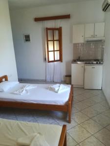 a room with a bed and a kitchen with a window at Dolphins House in Kinira