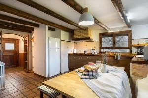 a kitchen with a wooden table and a white refrigerator at Alojamiento la Atalaya de Araguas in Araguás del Solano