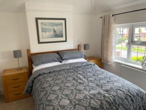 a bedroom with a bed and two windows at Spacious 3 bedroom house in heart of Hampton Court in East Molesey