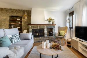 a living room with a couch and a fireplace at Alojamiento la Atalaya de Araguas in Araguás del Solano