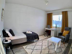 1 dormitorio con 1 cama, 1 silla y 1 mesa en Kaupunkikoti en Kemi