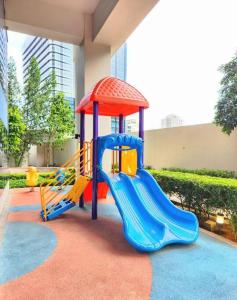 un parque infantil con tobogán en un edificio en BGC Cosy Spacious 1BR Uptown Parksuites with Balcony City View, en Manila
