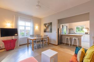 ein Wohnzimmer mit einem Tisch und einer Küche in der Unterkunft Kisana Residence - Lovely 2 Bedroom Apartment - Pointe aux Canonniers in Pointe aux Cannoniers