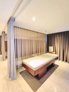 - une chambre avec un lit dans une chambre avec des rideaux dans l'établissement BGC Cosy Spacious 1BR Uptown Parksuites with Balcony City View, à Manille