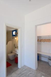 a bathroom with a white toilet and a sink at Villa Nidito Santorini in Vlychada Beach