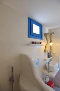 bagno con vasca e lavandino di Villa Nidito Santorini a Vlychada Beach