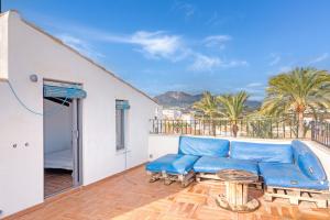a living room with a blue couch and a balcony at Ca Xotxim in Altea