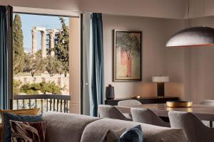 a living room with a couch and a table and a window at Acropolis Grand Suite in Athens